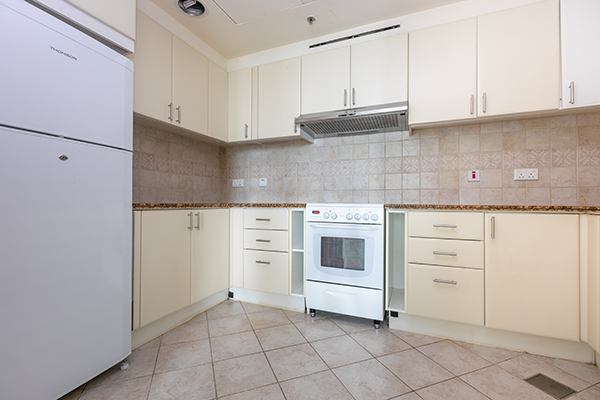 Old looking furnished kitchen with tiles flooring in an apartment