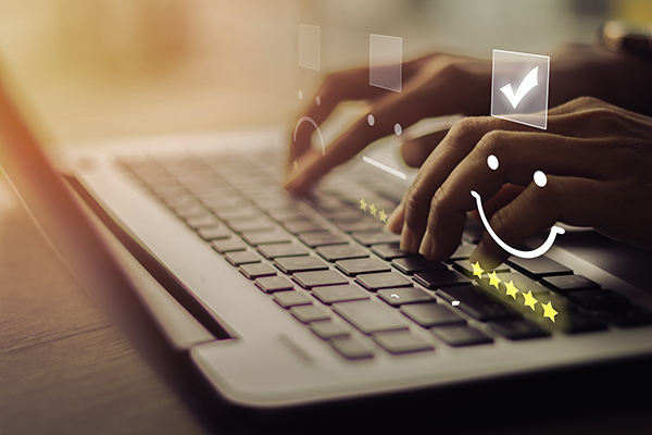 Businesswoman pressing smiley on keyboard laptop .Customer service evaluation concept. 