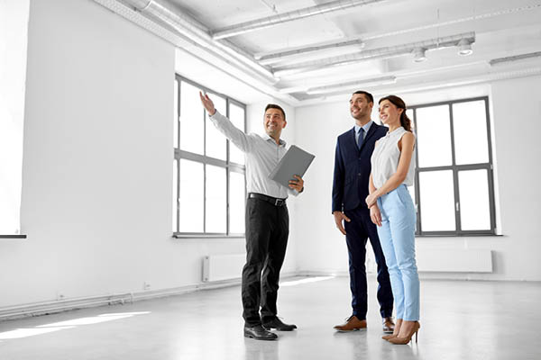 Realtor with young couple viewing a room.