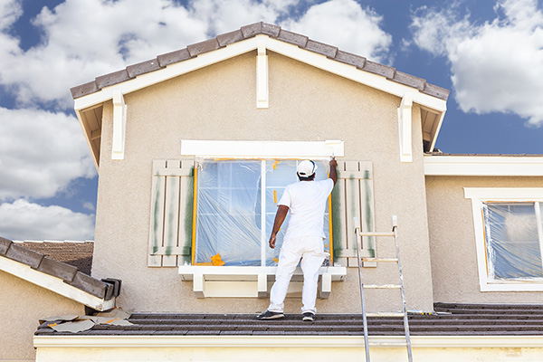 Busy House Painter Painting the Trim And Shutters of A Home.