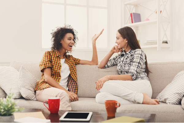 Two friends talking on a couch.