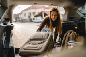 Woman pulling her bag out of her car